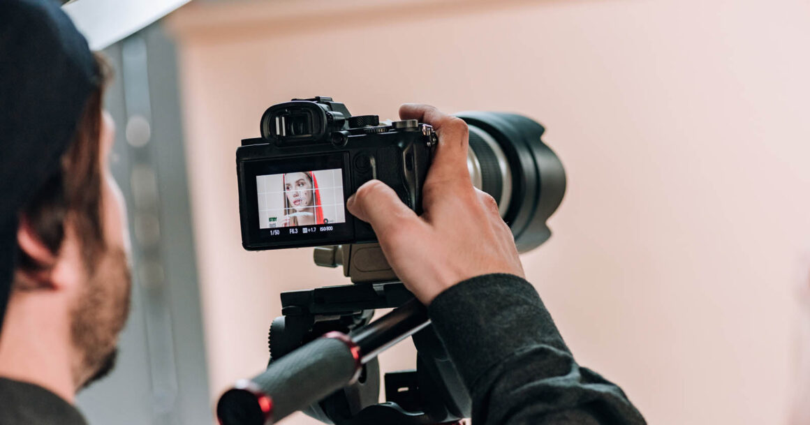 videographer changing settings on camera