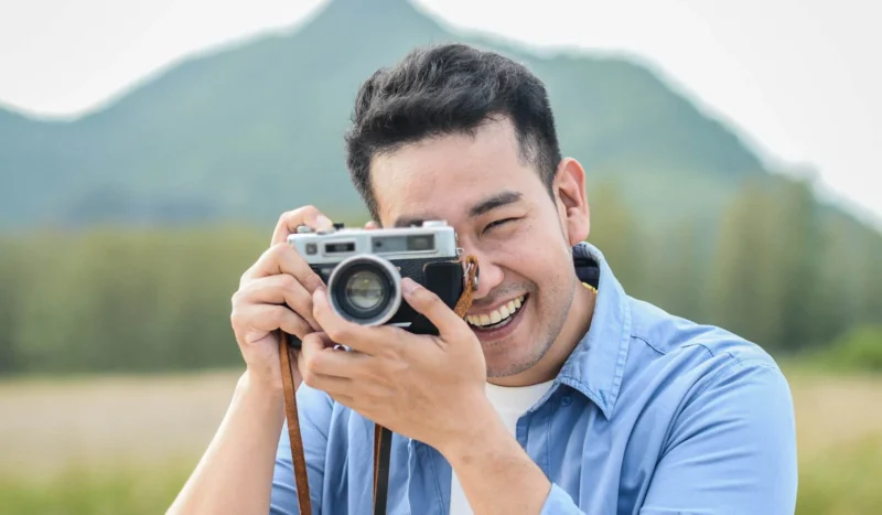 asian man shooting film camera