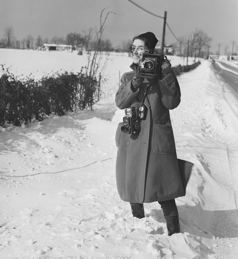 Marion Post Wolcott smiling with a speed graphic