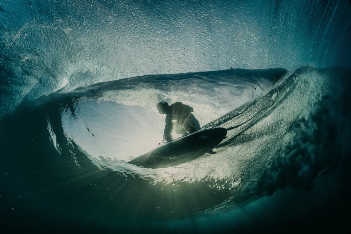 a surfer glides over the water
