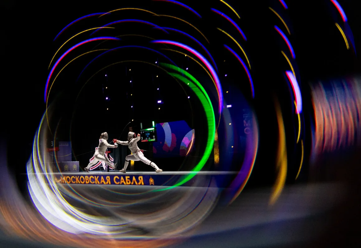 two fencers bout in a Dark room with colorful lights swirling around