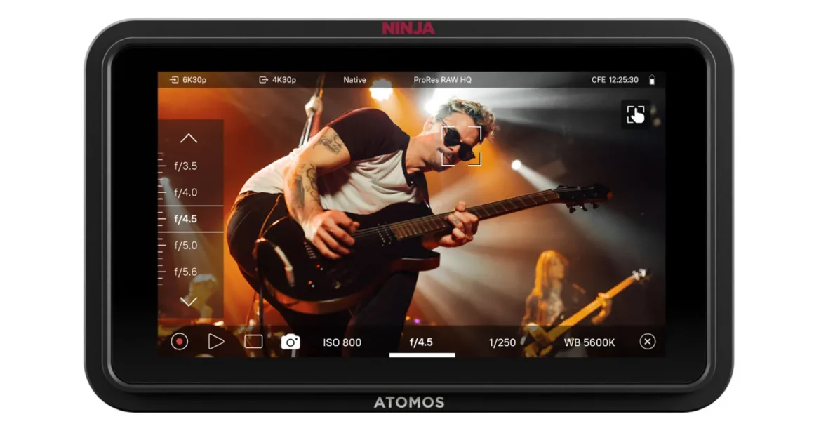 Atomos Ninja RAW Tanıtıldı: 5 İnç HDR Monitör-Kayıt 2 A camera monitor screen displays a live recording of a guitarist performing on stage, with camera settings such as ISO, shutter speed, and white balance visible on the sides of the display.
