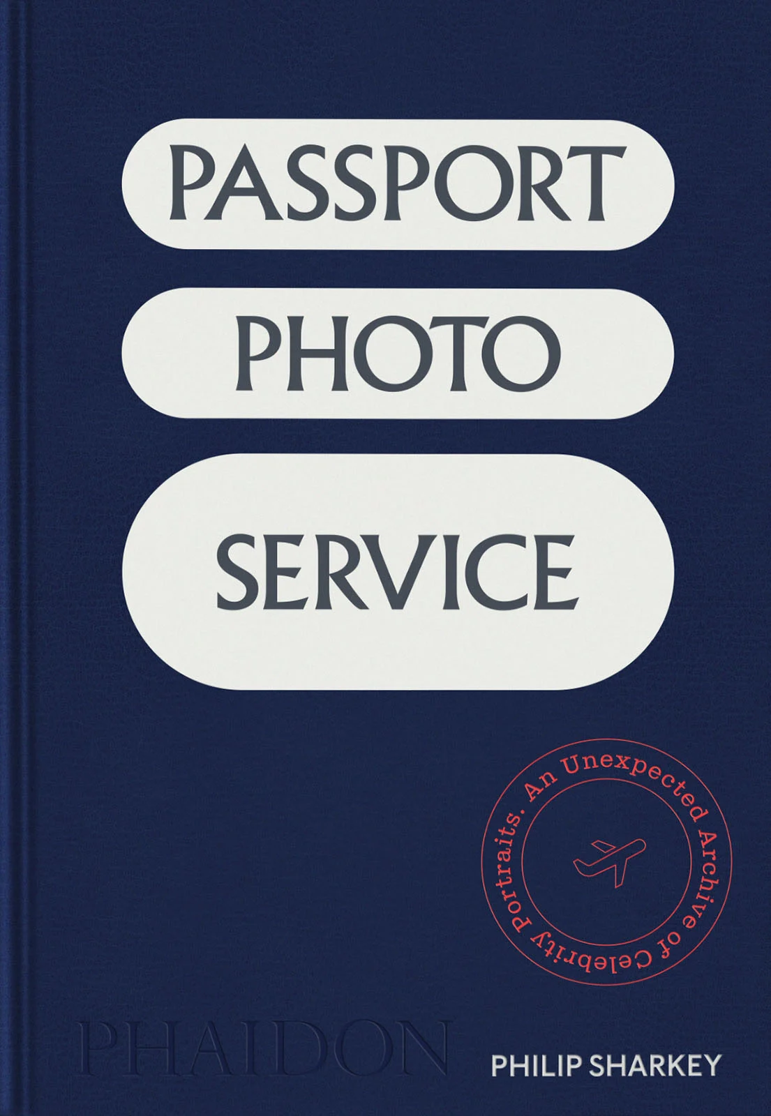 Koyu mavi kapaklı bir kitap; üzerinde 'PASSPORT PHOTO SERVICE' yazısı beyaz bloklar içinde yer alıyor ve sağ altta kırmızı bir damga bulunuyor.