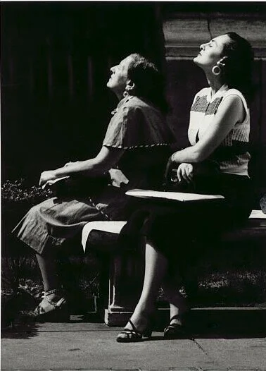 Güneş altında oturan iki kadın, şehir ortamında sakin bir an, 1954.