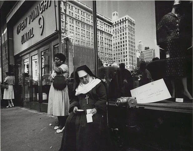 Bir mağaza vitrininin önünde oturan rahibe, 1958.