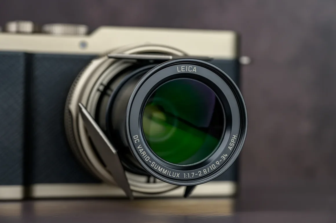 Panasonic Lumix L10 İncelemesi: Kompakt Kameraların Geri Dönüşü 2 Siyah ve gümüş dokulu gövdeye bağlı Leica lensin yakın plan görüntüsü. Lens çevresinde "DC VARIO-SUMMILUX 1:1.7-2.8/10.9-34 ASPH." yazısı yer alıyor.