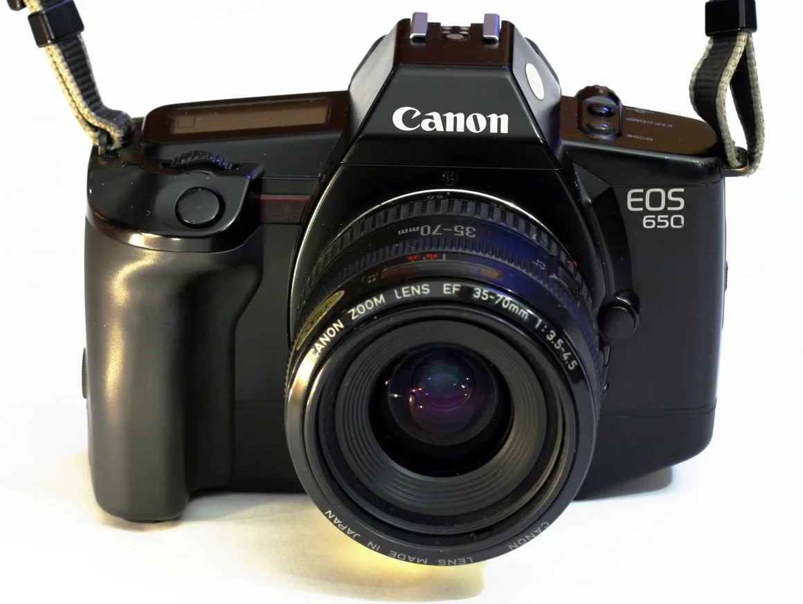 Canon Zoom Lens EF 35-70mm f/3.5-4.5 takılı Canon EOS 650 film kamerasının önden görünümü; lens, gövde ve askı bağlantıları görünür durumda.