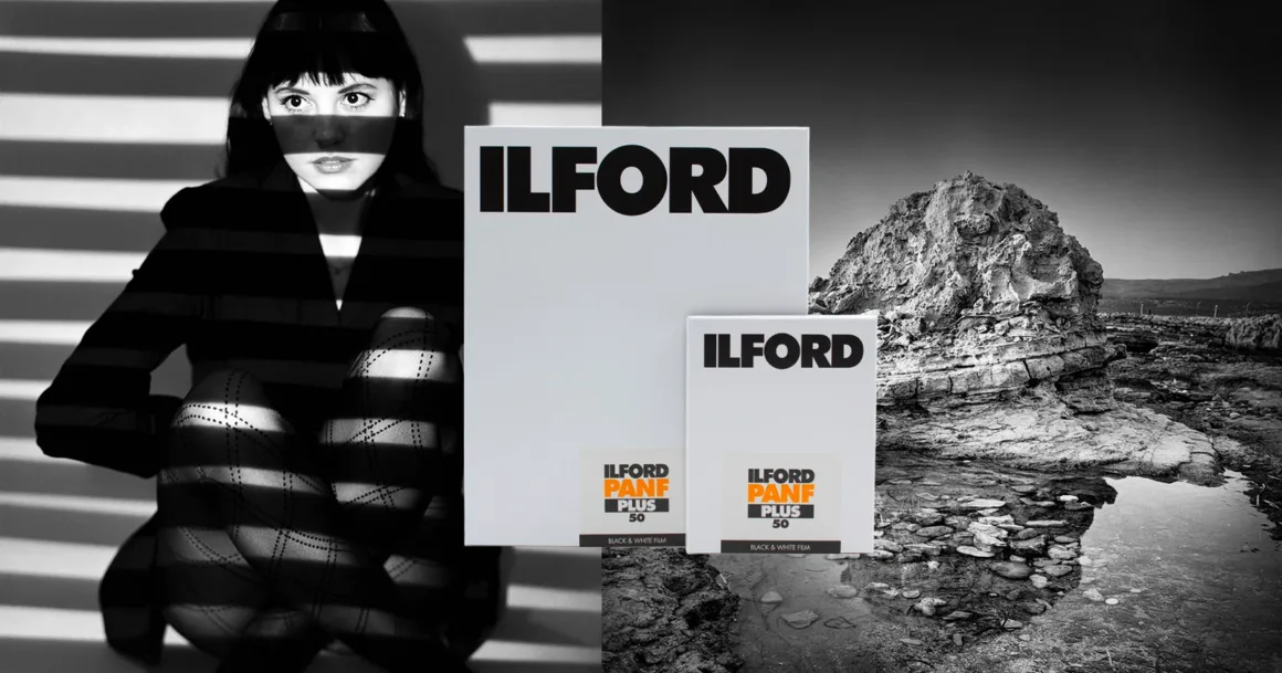 Ilford Pan F Plus Artık 4×5 ve 8×10 Büyük Format Filmde
Yüzü ve bacakları boyunca dramatik ışık ve gölge çizgileri bulunan bir kadın, üzerinde "ILFORD PANF PLUS 50" yazan iki kutunun yanında oturuyor. Arka planda siyah beyaz kayalık bir manzara ve su görülüyor.