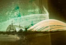 the rounded metal shield over chornobyl looms in the distance with streaks of light next to it