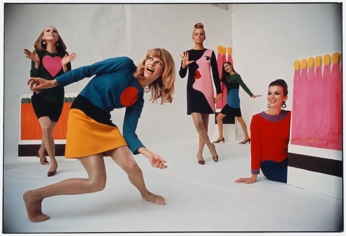 Yves Saint Laurent ve Fotoğraf: Bir Moda Efsanesini Şekillendiren 40 Yıl 1 Yves Saint Laurent ve Fotoğraf: Bir Moda Efsanesini Şekillendiren 40 Yıl
Renkli ve grafik desenli mod elbiseler giyen dört kadın, arka planda büyük ve parlak kibrit çöpü dekorlarının bulunduğu beyaz bir odada eğlenceli pozlar veriyor. Dinamik duruşları ve ifadeleri 1960'ların moda ruhunu yansıtıyor.