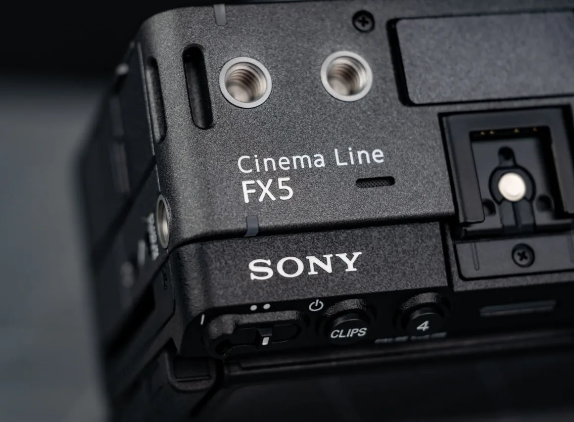 Siyah Sony Cinema Line FX5 kamera gövdesinin, marka logosunu, model adını ve bağlantı noktalarının bir bölümünü gösteren yakın plan görünümü.