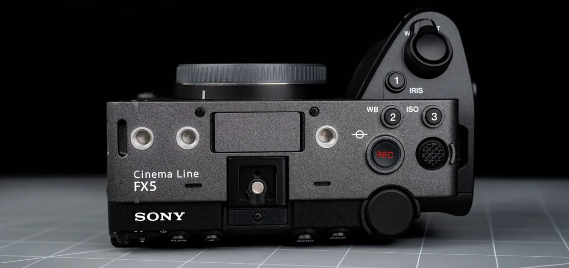 Kontrol düğmeleri, ayar tekerlekleri, REC tuşu ve lens yuvasını gösteren Sony Cinema Line FX5 gövdesinin üstten görünümü.