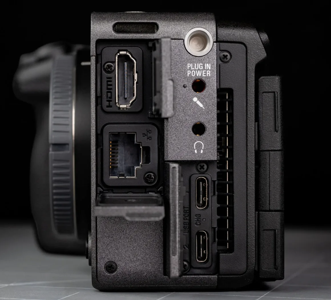 Sony FX5 Neden Sony'nin Bugüne Kadarki En Önemli Sinema Kamerası? 10 HDMI, LAN, USB-C, kulaklık ve mikrofon girişleri ile güç bağlantısını gösteren bir kameranın yan panelinin yakın plan görüntüsü.