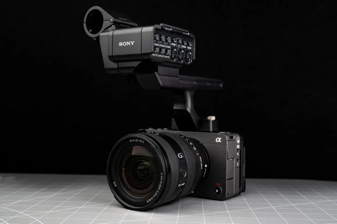 Büyük objektif ve harici ses arabirimi takılı profesyonel Sony dijital sinema kamerası gri kare desenli bir yüzey üzerinde.