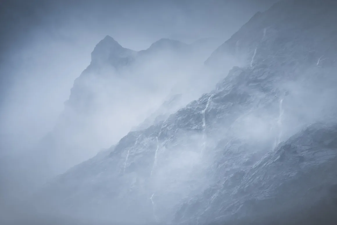 Michael Shainblum, Yeni Zelanda'nın Olağanüstü Güzelliğini Yeniden Yorumluyor 7 Kalın sis tabakalarının arasından yükselen dramatik dağ zirveleri; koyu renkli sarp kayalıklar pusun içinde güçlükle seçiliyor ve sahneye gizemli bir atmosfer kazandırıyor.