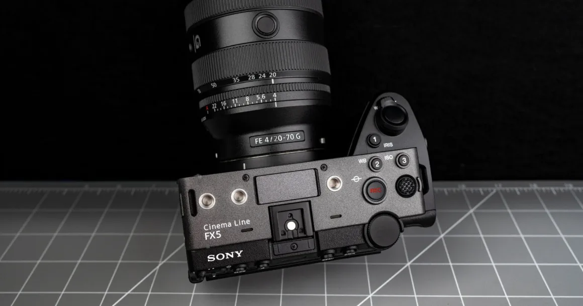 Sony Cinema Line FX5 kamera, FE 20-70mm F4 G objektifle birlikte gri desenli bir yüzey üzerinde yukarıdan görülüyor. Kamera üzerindeki kontrol düğmeleri ve tuşlar net biçimde seçilebiliyor.