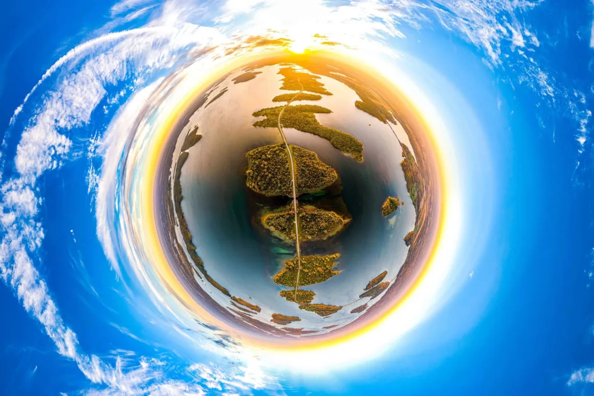 2026 BMC Ekoloji ve Zooloji Fotoğraf Yarışmasının Kazananları 25 Küçük gezegen efektiyle çekilmiş 360 derecelik panoramik görüntüde, bir göldeki adalar dizisini aşan yol görülüyor.