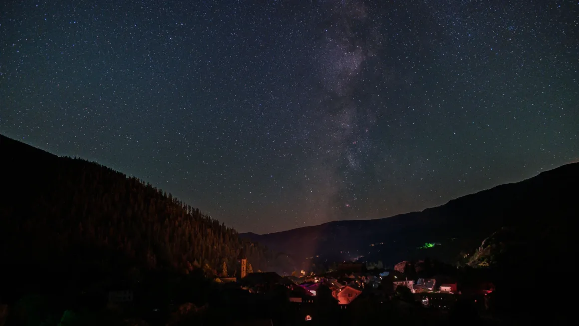 Dünyanın En Karanlık Gökyüzlerinin Güzelliğini Yansıtan 31 Ödüllü Fotoğraf 11 A small village nestled in a dark mountain valley under a clear night sky filled with stars and the Milky Way.