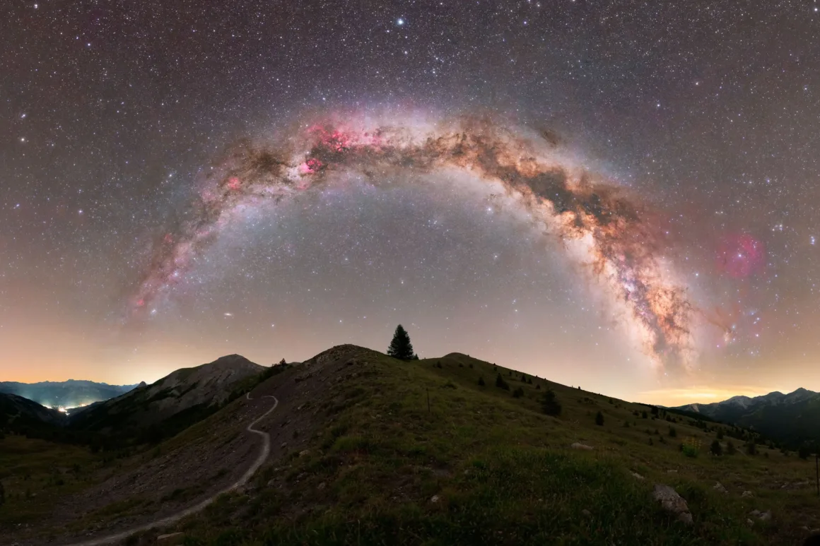 Dünyanın En Karanlık Gökyüzlerinin Güzelliğini Yansıtan 31 Ödüllü Fotoğraf 9 A panoramic view of the Milky Way arching over a grassy mountain ridge with a single tree at the summit.