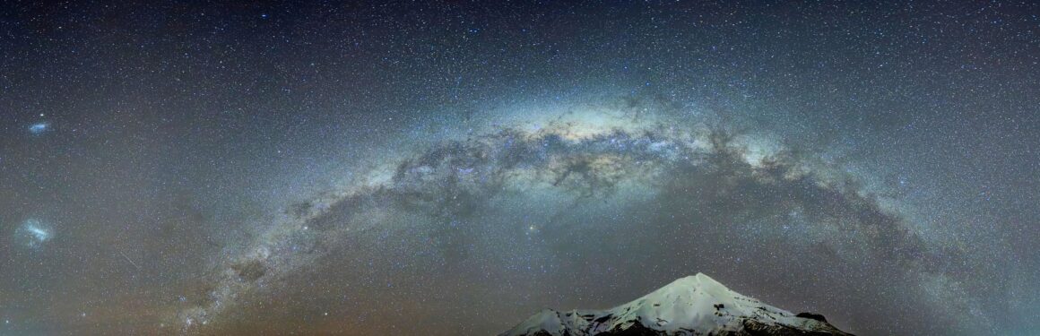 Dünyanın En Karanlık Gökyüzlerinin Güzelliğini Yansıtan 31 Ödüllü Fotoğraf 24 A panoramic view of the Milky Way galaxy arching over a snow-capped mountain peak at night.