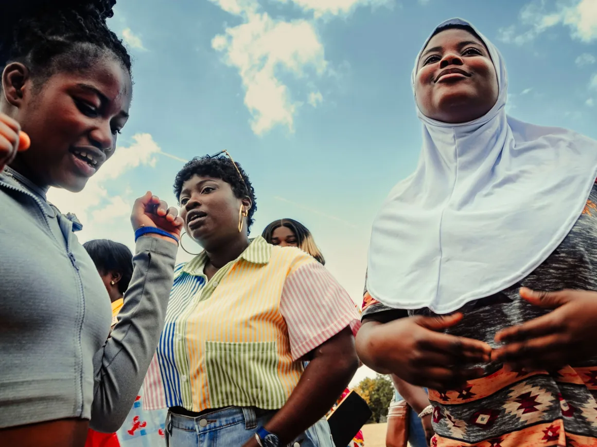 Winston Taylor Photo Portrait Prize 2026 9 A group of young women stand together outdoors against a blue sky, with one woman wearing a white hijab and another in a colorful striped shirt.