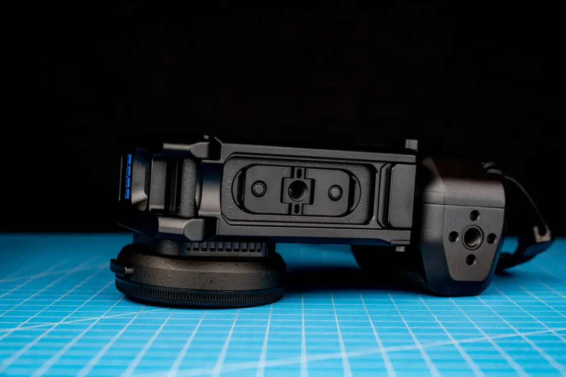 GoPro Mission 1 Pro ILS İncelemesi: Yenilikçi Ama Kime Göre? 20 Objektif kapağı takılı siyah GoPro kamera, mavi ızgaralı kesim matının üzerinde duruyor.