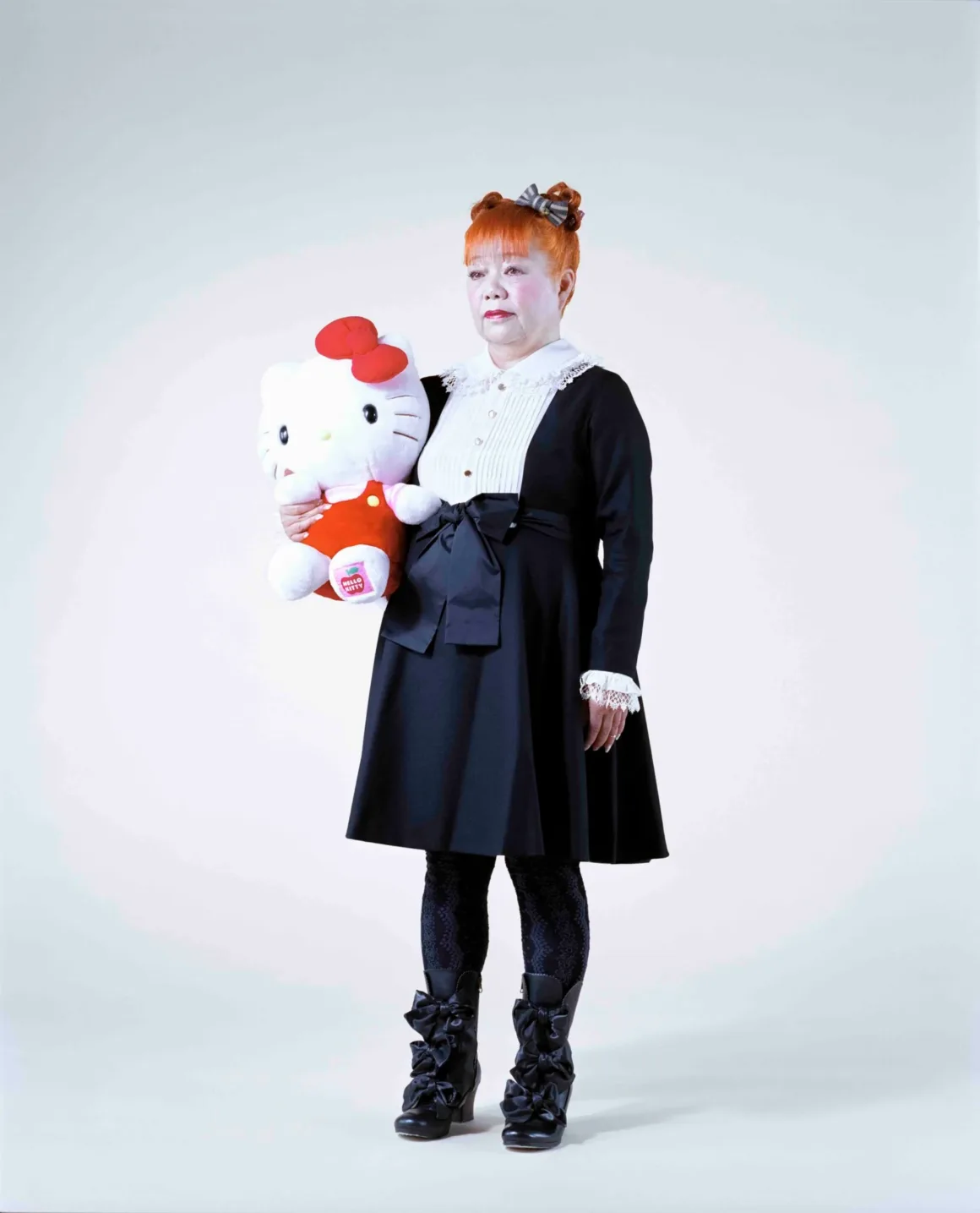 Fotoğrafçı, Japonya’nın Unutulmuş 19. Yüzyıl Fotoğraflarını Buldu ve Bugün Yeniden Yorumladı 27 Turuncu saçları ve siyah elbisesiyle Hello Kitty tasarımcısı Yuko Yamaguchi, büyük bir Hello Kitty oyuncağı tutuyor.