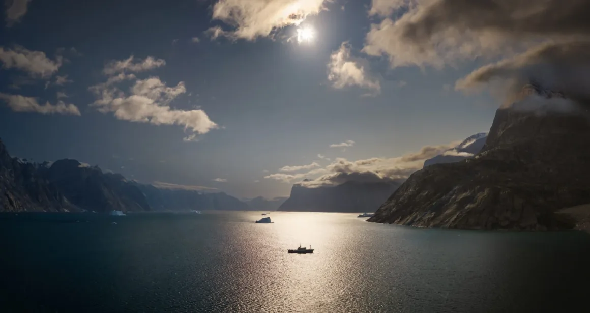 Scoresby Sund’da Işıklar Söndüğünde: Arktik’te Tam Güneş Tutulması 15 Scoresby Sund’da Işıklar Söndüğünde: Arktik’te Tam Güneş Tutulması
Küçük bir tekne; bulutlu bir gökyüzünün altında, yüksek kayalık dağlar ve etrafa dağılmış buzdağlarıyla çevrili, güneş ışığı alan sakin bir suyun üzerinde yüzüyor.