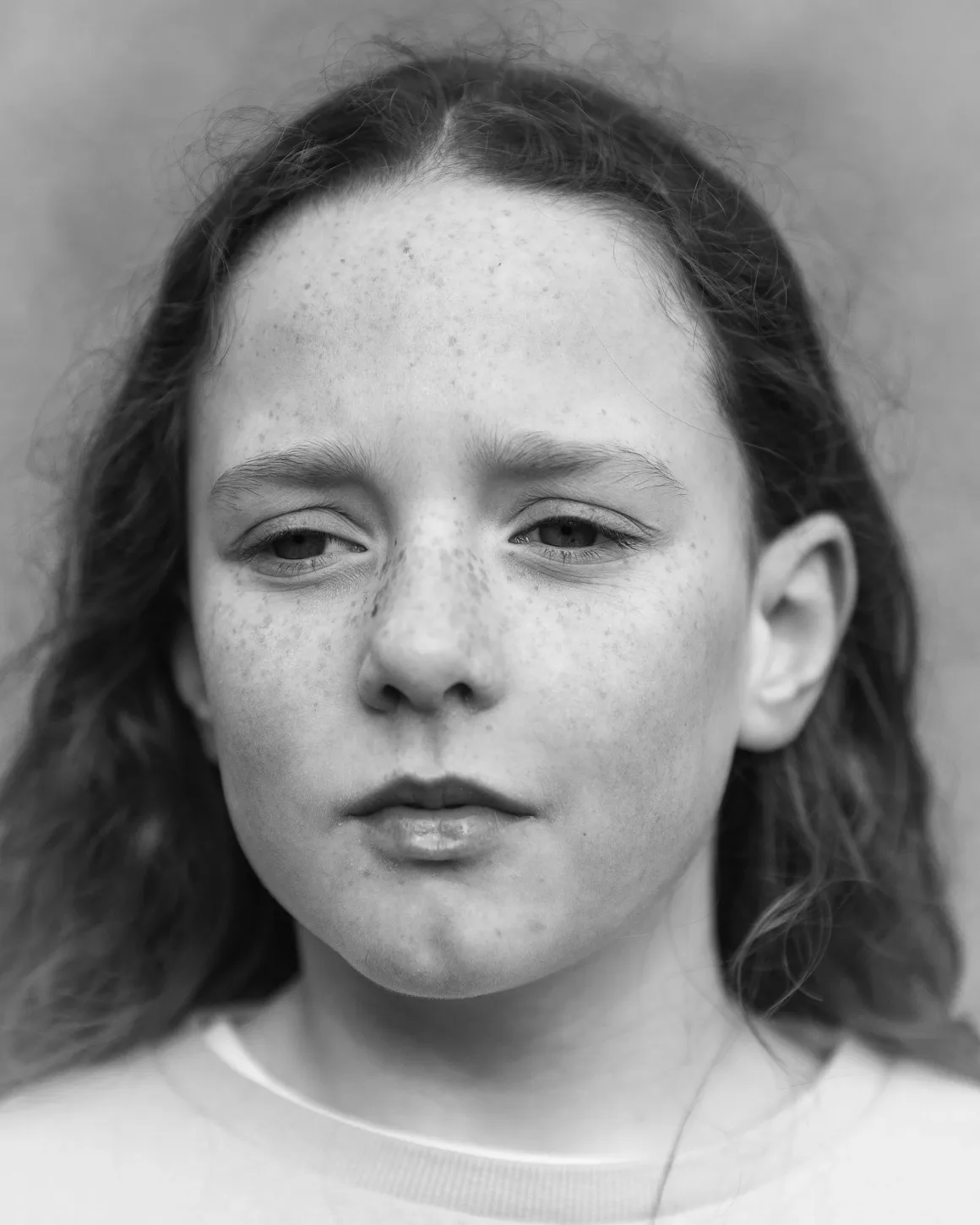 Winston Taylor Photo Portrait Prize 2026 7 Çilleri, uzun dalgalı saçları ve ifadesiz bakışlarıyla genç bir kişinin siyah-beyaz yakın plan portresi.