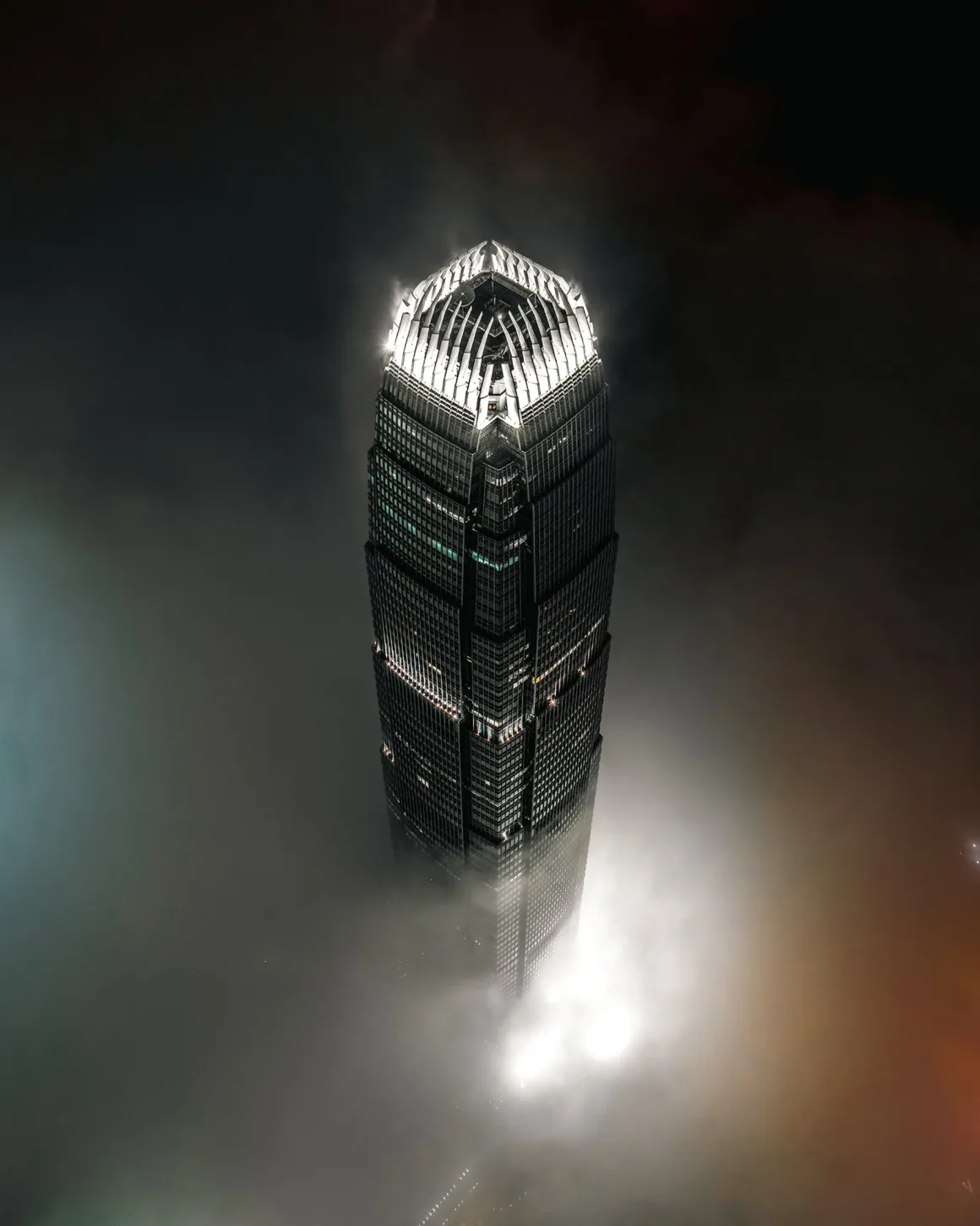 2026 European Photography Awards: Dünyayı Görmenin Farklı Yolları 21 Bir gökdelen gece boyunca alçakta asılı duran yoğun bulut tabakasının üzerine yükselirken, aydınlatılmış tepesi karanlık gökyüzünde parlıyor.