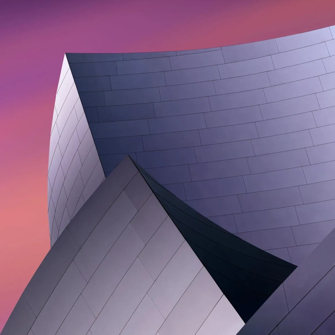 Minimalist Fotoğraf Ödülleri 2026: Kazananlar Sadeliğin Gücünü Gösteriyor 29 Curved, metallic architectural panels overlap against a gradient sky transitioning from pink to purple.