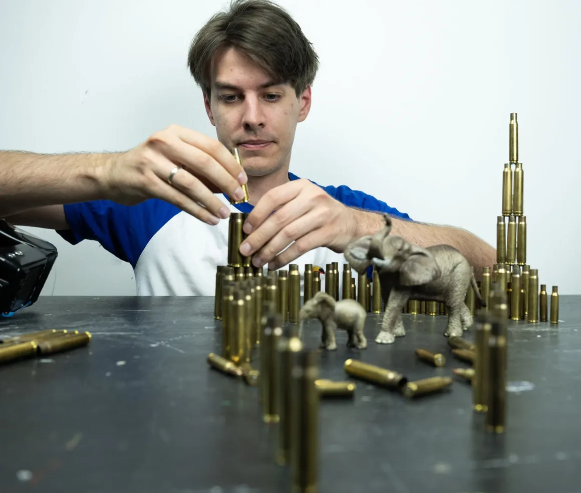 Doğanın Yerini Atıkların Aldığı Bir Dünya: Benedek Lampert'in Yeni Fotoğraf Serisi 10 A man in a blue and white shirt carefully stacks brass bullet casings on a table next to two toy elephants.