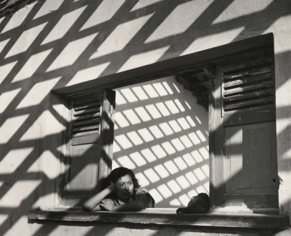 Getty Sergisi Meksika Fotoğrafının Evrimini İnceliyor 3 Getty Sergisi Meksika Fotoğrafının Evrimini İnceliyor
Bir kadın, başını eline yaslamış pencereden dışarı bakarken kafesin geometrik gölgeleriyle çerçeveleniyor.