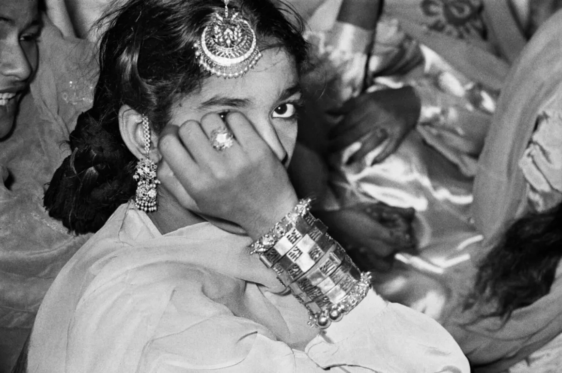 Frank Horvat Fotoğrafları: Hindistan ve Pakistan Kariyerini Nasıl Şekillendirdi?
Koyu saçlı ve maang tikka ile bilezikler dâhil geleneksel takılar takan genç bir kişi, eliyle yüzünün bir bölümünü kapatıyor.