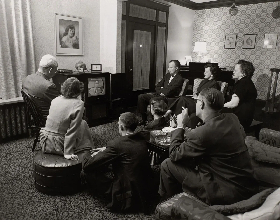 The Way We Never Were: Savaş Sonrası Amerika Miti 25 Yedi kişilik bir grup salonda oturarak televizyondaki erkeği izliyor.