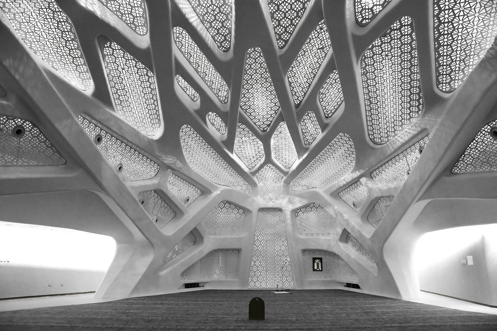 Sony World Photography Awards 2027’ye Katılmanız İçin 15 İlham Verici Fotoğraf 30 A modern, white interior space with a complex, organic ceiling structure featuring intricate geometric cutouts that filter light.