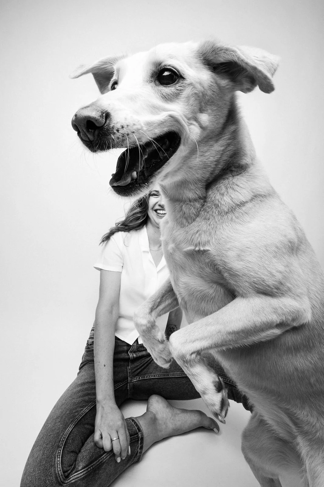 Dog Photography Awards 2026’nın Kazananları Açıklandı 29 Siyah-beyaz portrede yerde oturan kadın ve ön planda yüzünün bir bölümünü kapatan büyük köpek.