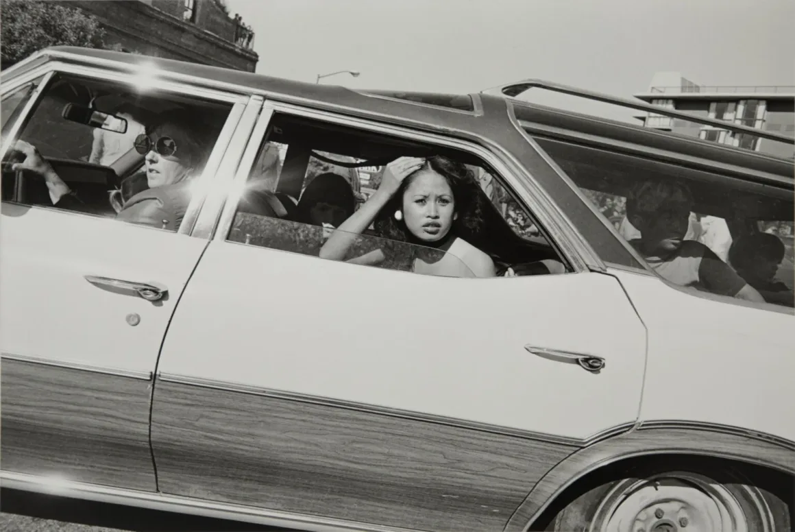 Henry Wessel: Direksiyon Başından 1980’lerin Kaliforniya’sı 18 Henry Wessel’in siyah beyaz fotoğrafında, ahşap kaplamalı station wagonun penceresinden dışarı bakan kadın ve içerideki yolcular.