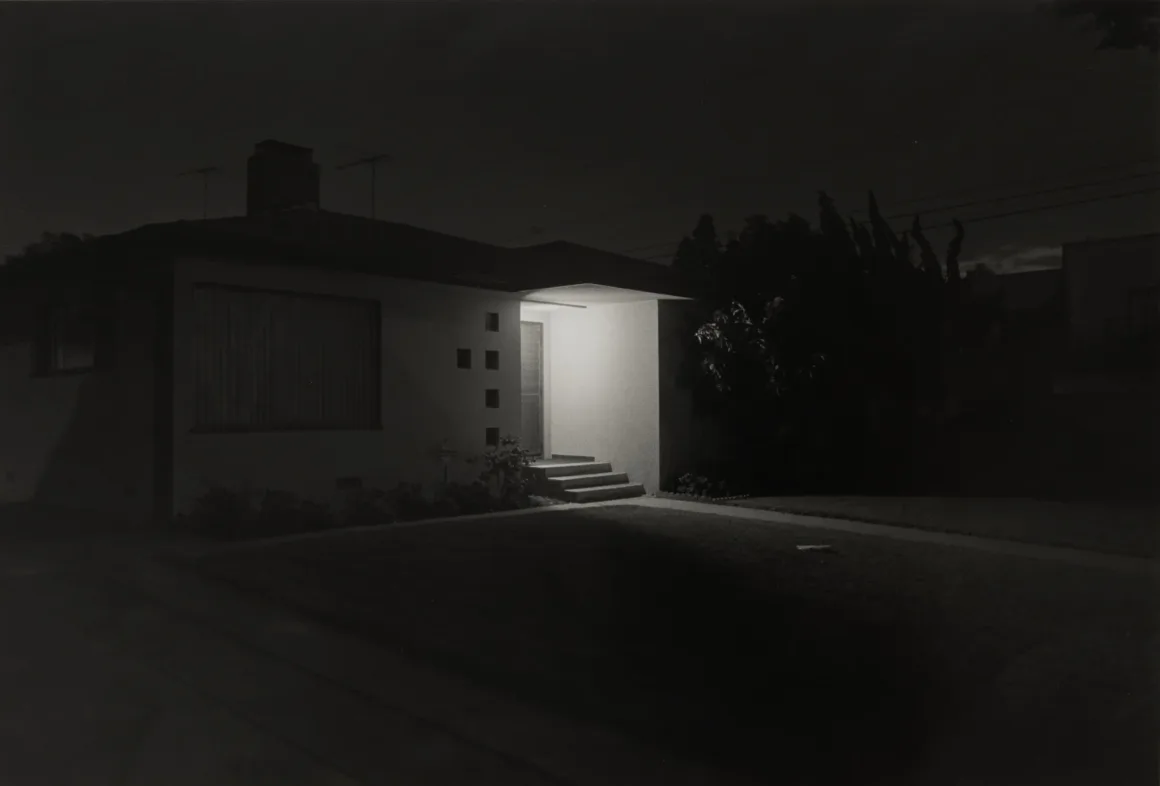 Henry Wessel: Direksiyon Başından 1980’lerin Kaliforniya’sı 21 Gecenin karanlığında, girişi parlak biçimde aydınlatılmış tek katlı ev.