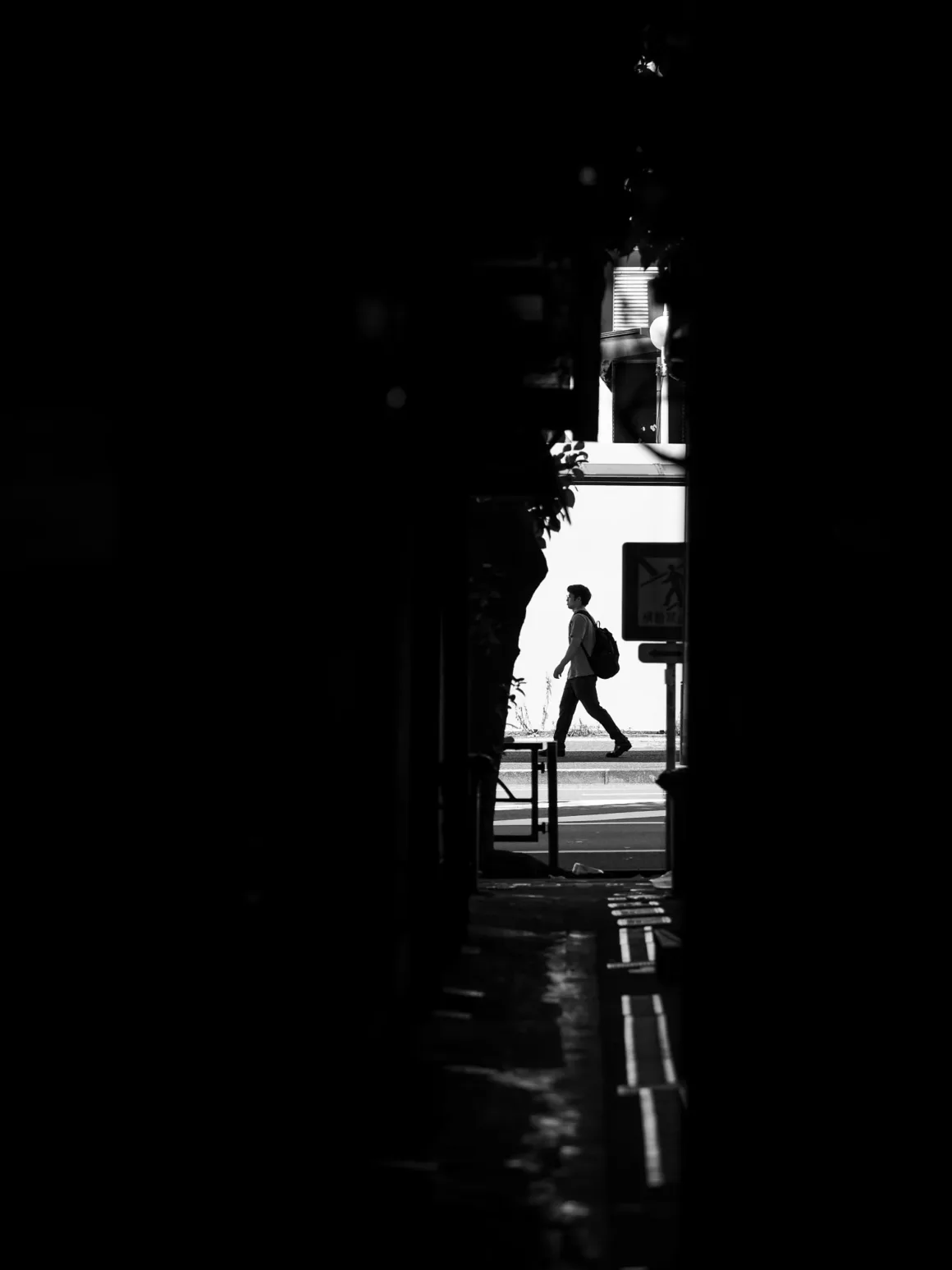 OM System PEN İncelemesi: Tanıdık Ama Son Derece Şık 51 A person with a backpack walks across a bright street as seen through a dark, narrow alleyway.