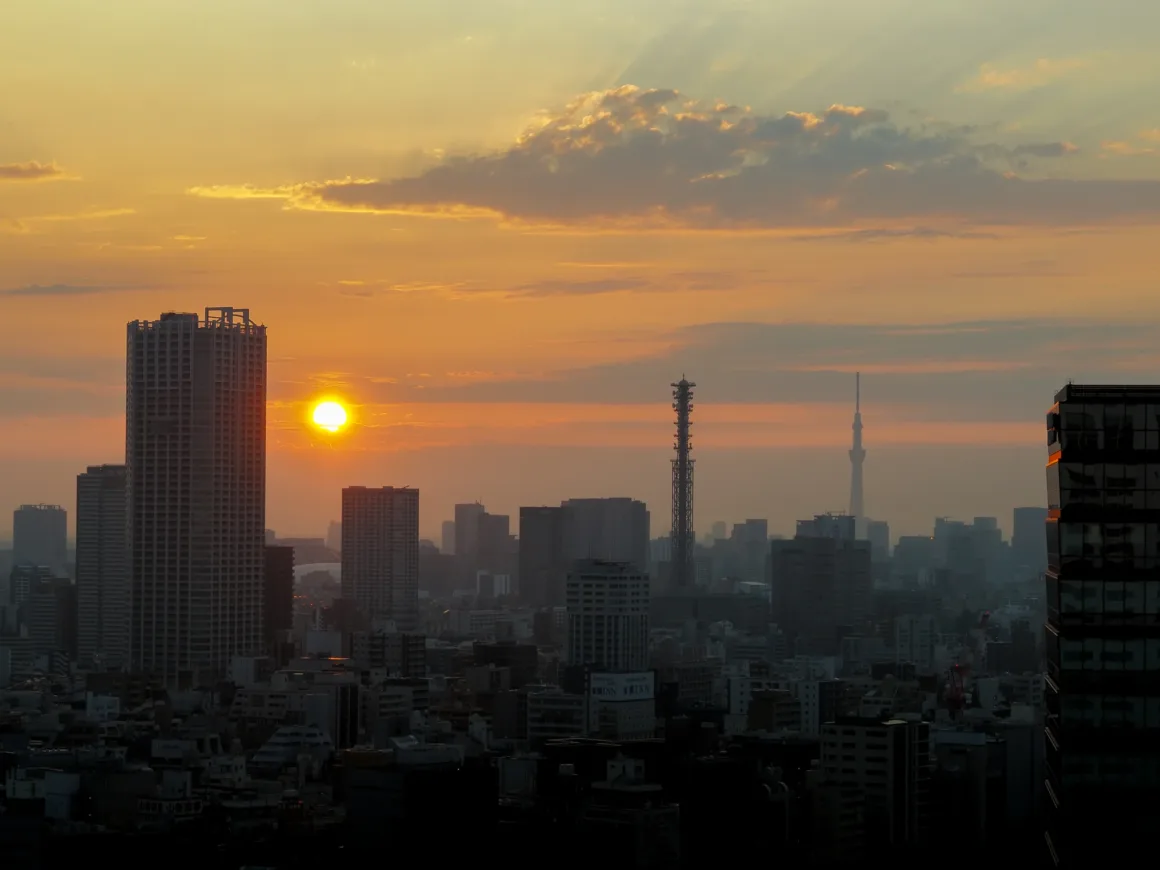 OM System PEN İncelemesi: Tanıdık Ama Son Derece Şık 43 A sunset over a dense city skyline with a tall communications tower and the Tokyo Skytree visible in the distance.