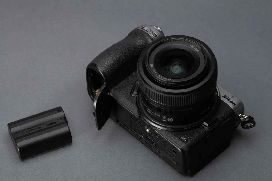 Nikon Z5IIC İncelemesi: Küçük Gövdeden Çok Daha Fazlası 45 Nikon Z5IIC üstten görülüyor; pili fotoğraf makinesinin yanında duruyor.