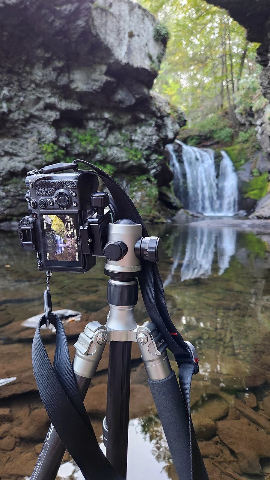Şelale Fotoğrafçılığı: Yeni Başlayanlar İçin Kapsamlı Rehber 20 Şelalenin önündeki sığ derede duran tripod üzerindeki makinenin ekranında sahnenin ön izlemesi görülüyor.
