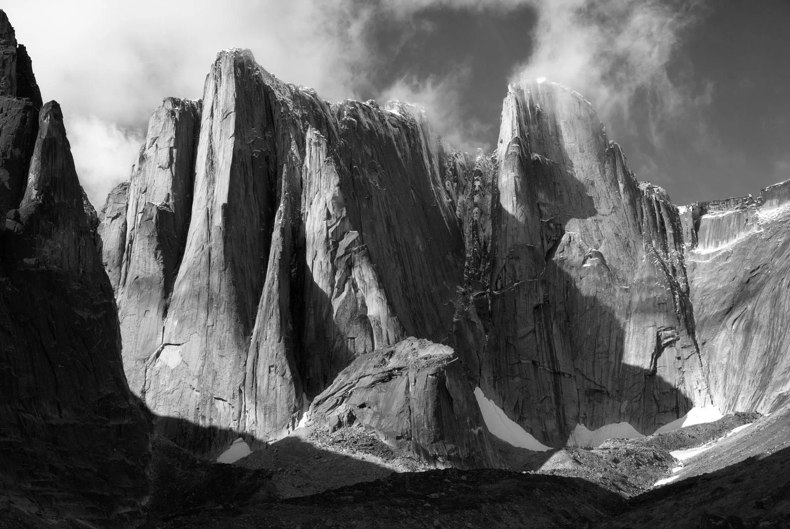 Natural Landscape Photography Awards 2026’nın Kazananları Açıklandı 81 A black and white view of towering, jagged granite cliffs rising above a rocky, snow-dusted mountain valley.