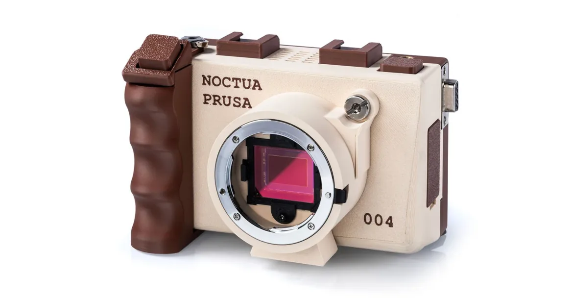 A 3D-printed digital camera in a beige and brown color scheme, labeled "NOCTUA PRUSA" and "004," featuring an exposed image sensor and a prominent grip.