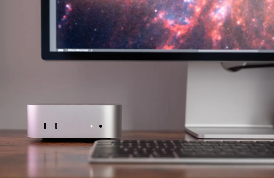 M6 Mac mini İncelemesi: Fotoğrafçılar İçin Yeterince Güçlü mü? 20 Renkli galaksi görüntüsü gösteren monitörün ve siyah klavyenin yanındaki gümüş Mac mini