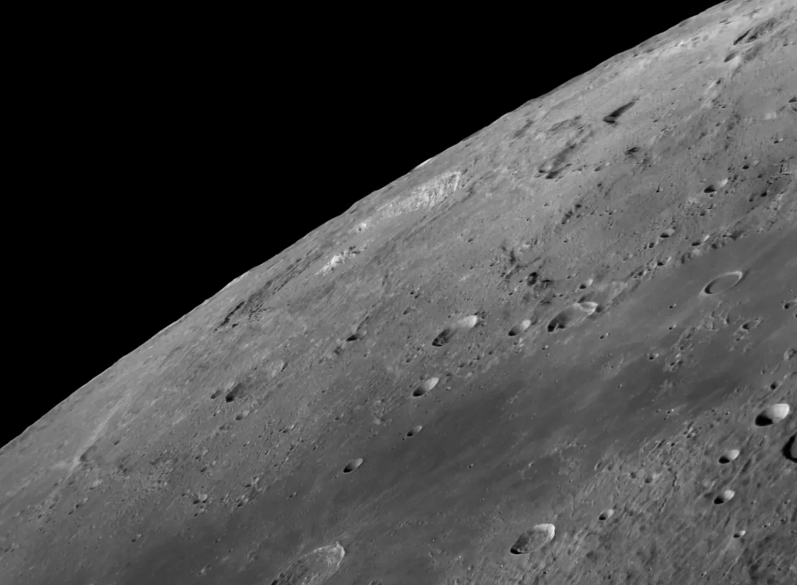 Astronomy Photographer of the Year 2026: Bu Dünyadan Olmayan 31 Kazanan 29 A high-angle view of the Moon's cratered surface showing a dark, smooth mare region meeting a rugged, light-colored highland.