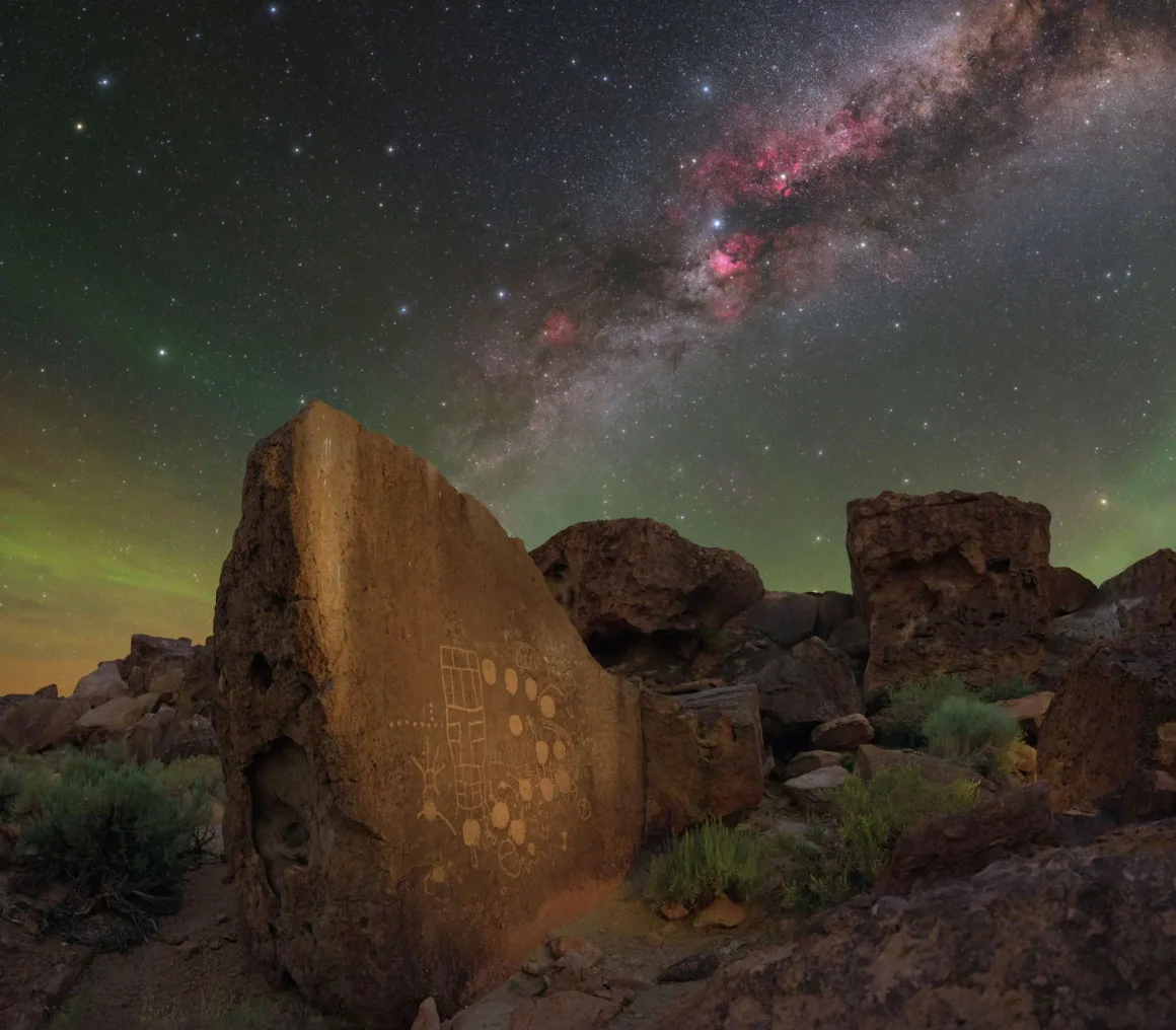 Astronomy Photographer of the Year 2026: Bu Dünyadan Olmayan 31 Kazanan 33 A large, weathered rock featuring ancient petroglyphs stands in a desert landscape beneath a vibrant, star-filled night sky.