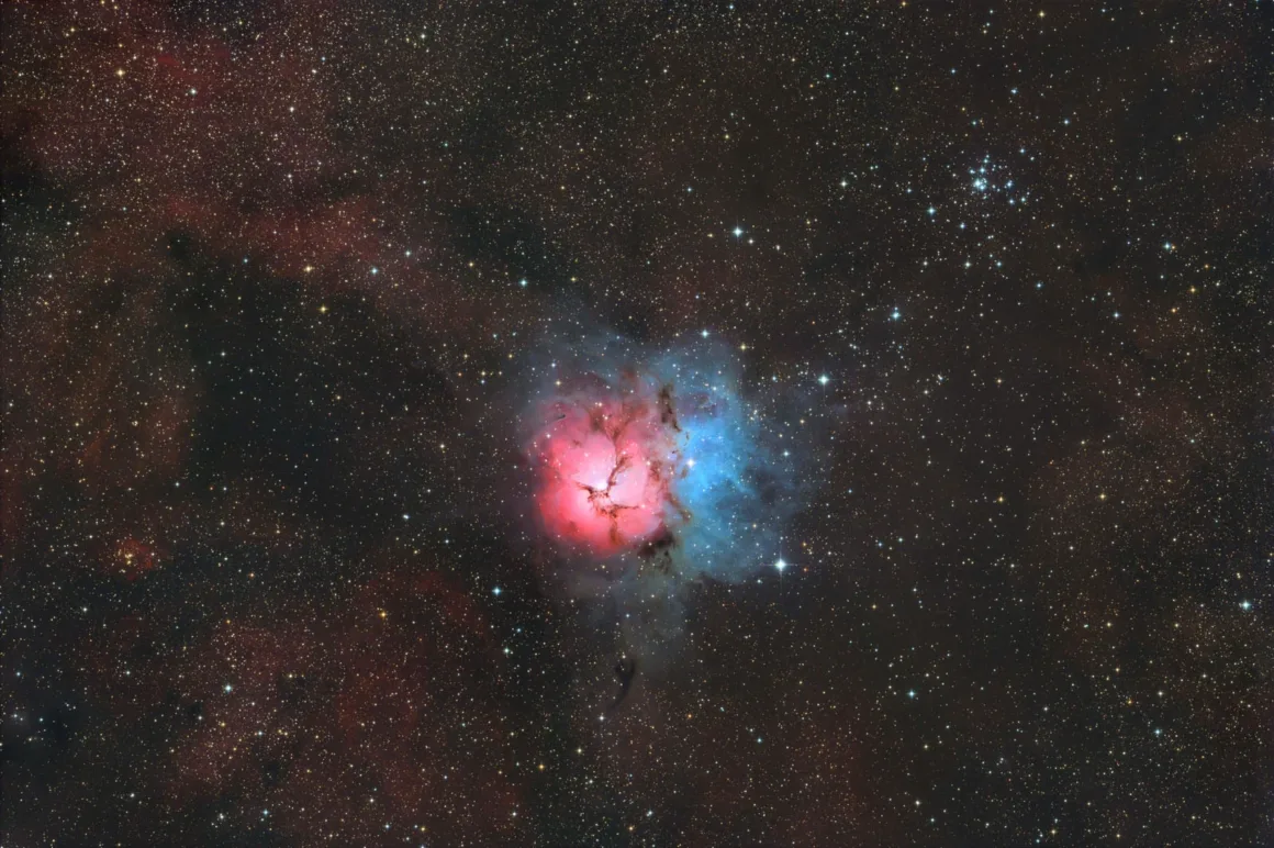 Astronomy Photographer of the Year 2026: Bu Dünyadan Olmayan 31 Kazanan 46 The Trifid Nebula glows with a bright pink emission region and a blue reflection nebula, surrounded by a dense star field.