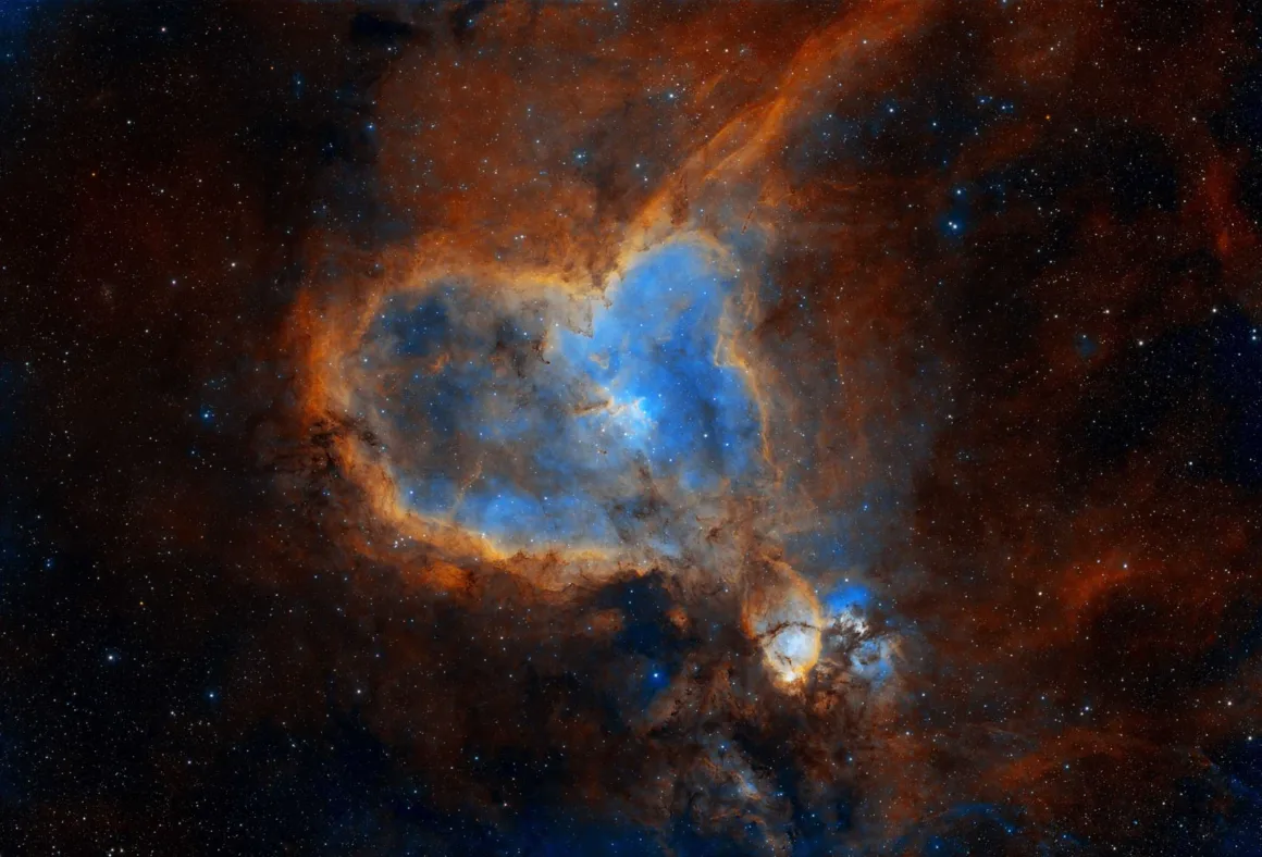 Astronomy Photographer of the Year 2026: Bu Dünyadan Olmayan 31 Kazanan 49 A large, heart-shaped nebula glows with vibrant blue and orange gases against a dark, star-filled background.